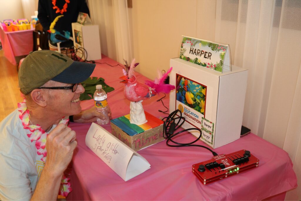 Audience member examining animatronic bird and listening to its associated audio
